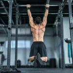 Entraînement traction : athlète en dead hang, omoplates engagées